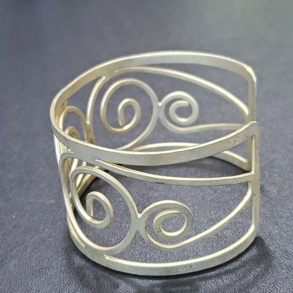 Gold tone swirly bangle cuff bracelet
